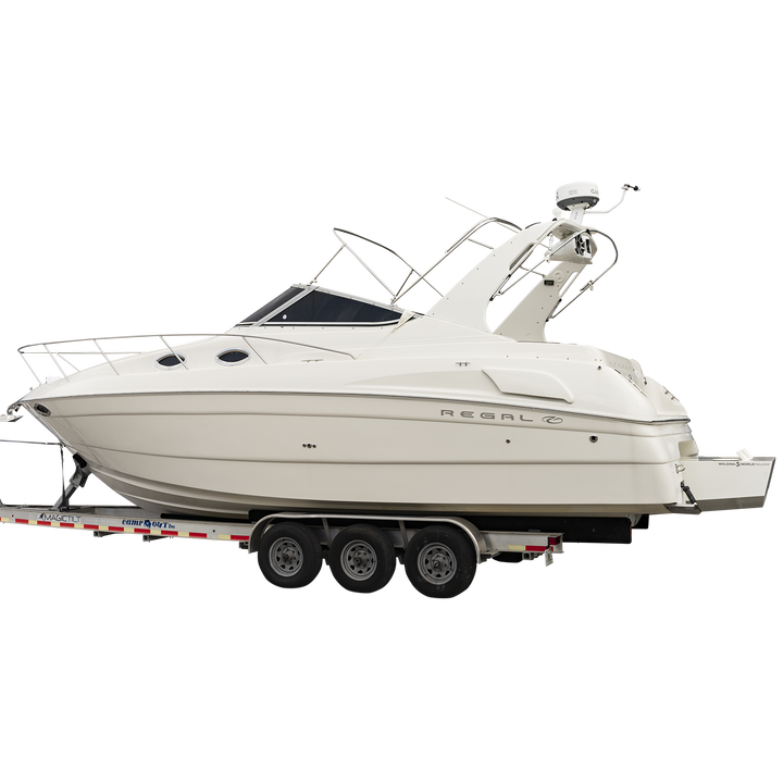 A white Regal Commodore 28 boat mounted on a triple-axle trailer, equipped with a custom high flotation twin outboard engine bracket. The boat features a sleek design with tinted windows and a radar arch. The background is transparent with a checkered pattern
