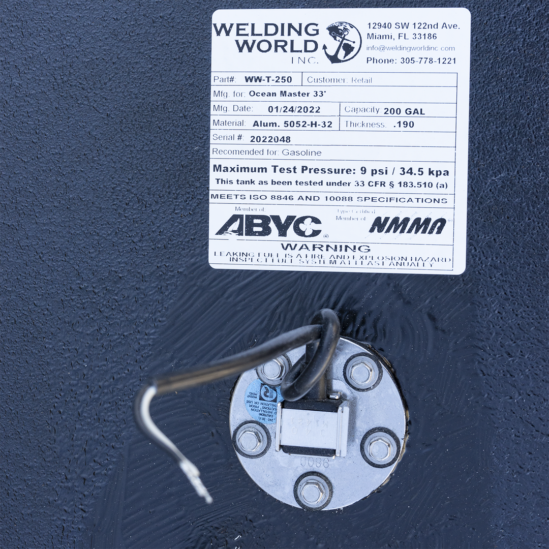 Certification label for the 200-gallon aluminum belly fuel tank designed for the Ocean Master 33 center console. Issued by Welding World Inc. (Part #WW-T-250, Serial #2022048), the label confirms the tank is constructed from .190″ 5052-H32 marine-grade aluminum and rated for gasoline containment. It meets 33 CFR § 183.510(a) with a maximum test pressure of 9 psi, and complies with ISO 8846 and ISO 10088 specifications. Additional endorsements include ABYC and NMMA membership. Printed warnings emphasize