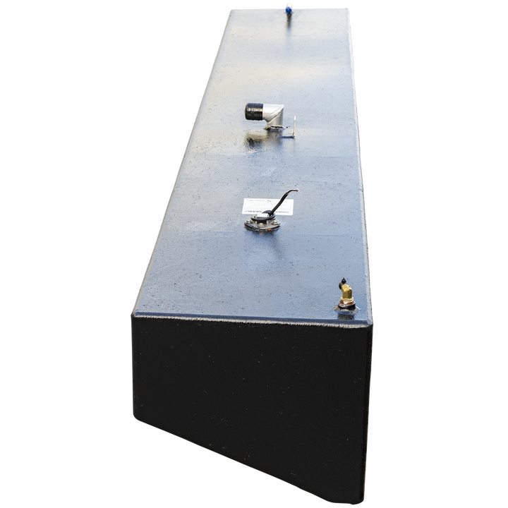 A high-angle, end-on view looking down the entire length of a very long, narrow boat fuel tank, emphasizing its length. The tank has a textured black coating and is set against a checkered background. A series of fittings are aligned down the center of the flat top surface, including a brass corner fitting, a fuel sending unit with a label, an L-shaped valve, and a small blue-tipped fitting at the far end