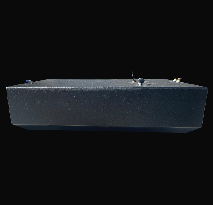 Longitudinal side-profile view of a 148-gallon primary fuel tank for an Intrepid Stoner 27, showcasing the uniform coal-tar epoxy finish, low-profile V-bottom design, and top-mounted fuel pickups and rigging ports.