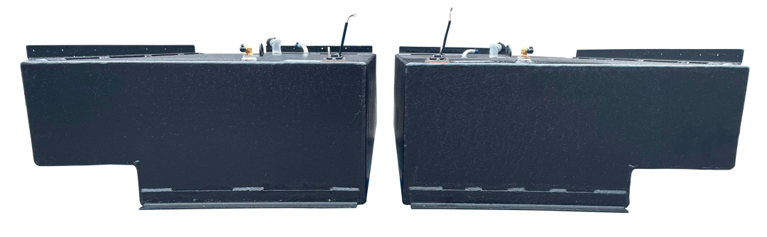 Straight side-on profile of the two black rectangular Stama 2001 marine fuel tanks, highlighting their long length, dark texture, and metal mounting rails along the upper edge.