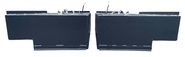 Straight side-on profile of the two black rectangular Stama 2001 marine fuel tanks, highlighting their long length, dark texture, and metal mounting rails along the upper edge.