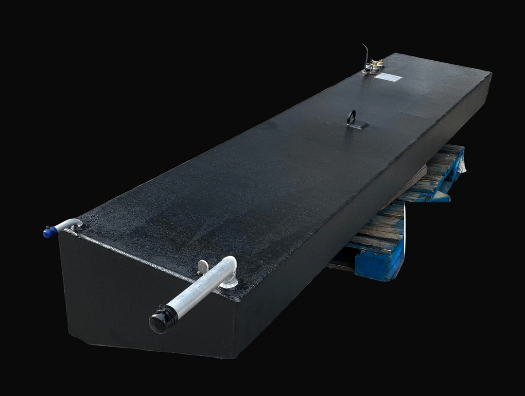 A high-angle product photograph of a long, black rectangular marine fuel tank, showcasing its textured surface and integrated hardware. Visible components include two brass fittings and an electrical wire located near the front, a single silver lifting eye in the center, and a silver fill neck with a vent tube at the far end.