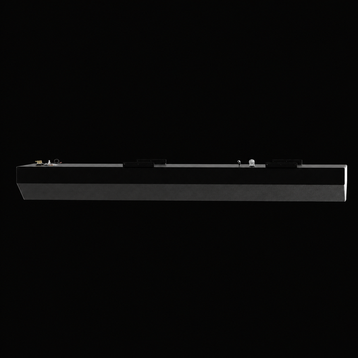 A full side-elevation perspective view of an elongated black Action Marine 25 replacement marine fuel tank. This 115-gallon capacity center-hull fuel cell showcases a slim, extended profile integrated with shallow V-shaped hull-conforming bottom contours designed by Welding World to sit flush inside the vessel's central bilge cavity. Fabricated from heavy-gauge marine-grade 5052-H32 aluminum, the entire unit is coated in an anti-corrosive, textured black TarGard epoxy finish and outfitted with multiple top-