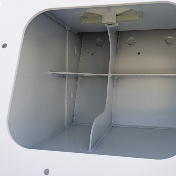 The interior of a white metal enclosure showing the Apex Triple NSP 3-Engine Bracket, which is a beige-colored, T-shaped component mounted at the top center inside the box, with a cable or wire hanging from it. The inside walls have visible welds and small hole