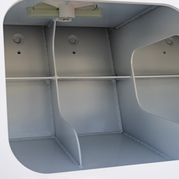 The interior of a metal enclosure showing the Apex Triple NSP 3-Engine Bracket, a beige-colored, T-shaped component mounted at the top center inside the box, with a wire hanging from it. The inside walls are smooth with visible welds and small holes