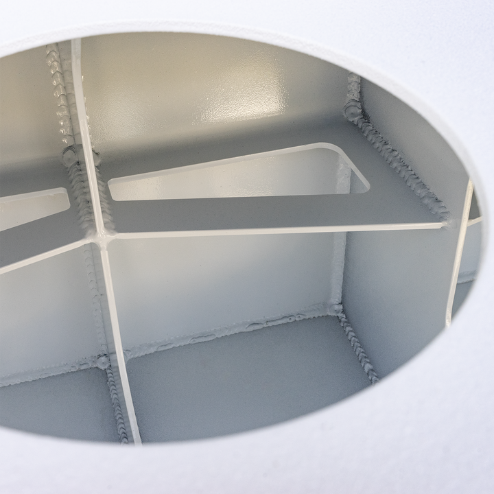 The interior of a white metal enclosure with welded dividers, showing the Apex Triple NSP 3-Engine Bracket mounted at the top center. The bracket is a beige-colored, T-shaped component with a wire hanging from it. The inside surfaces are smooth and painted white