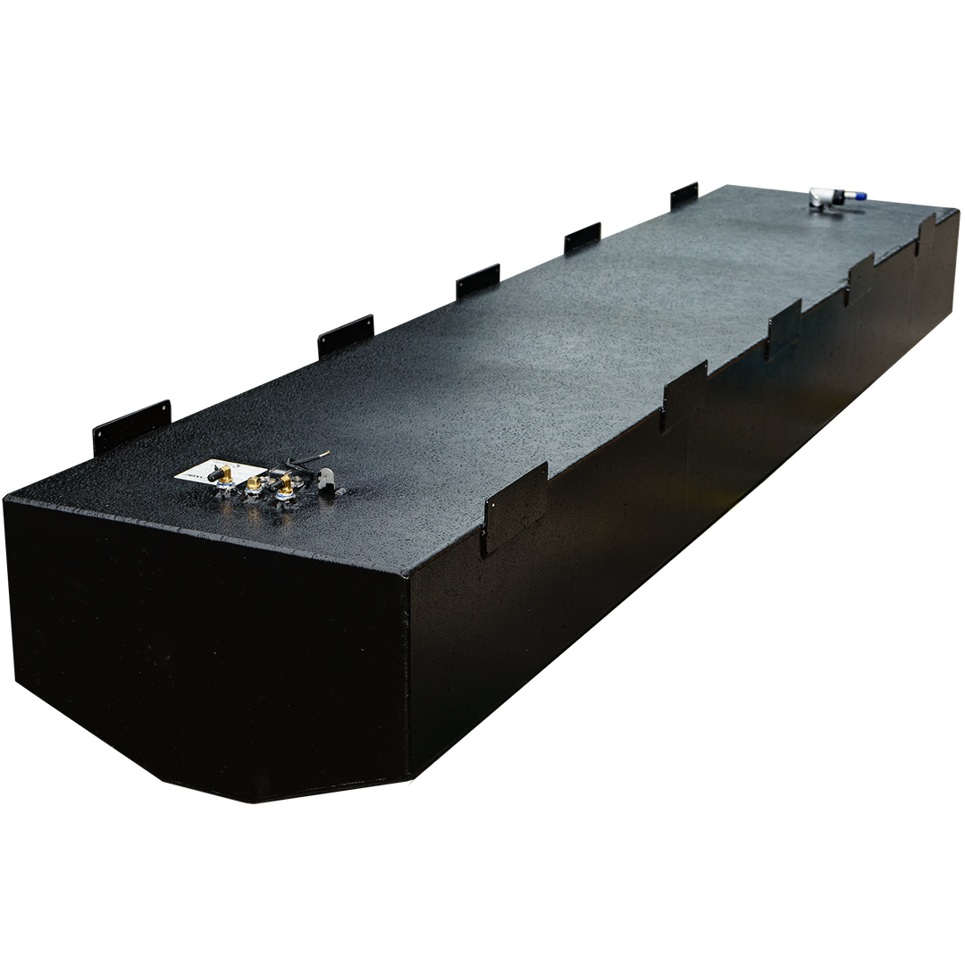 An angled, eye-level shot of a long, rectangular, black fuel tank, specifically a Baja 280 1990 - 204 gal. OEM replacement belly fuel tank (short version). The tank has a textured finish and features several metal fittings and connections on its top surface, along with multiple dark rectangular mounting tabs along its sides. The background is a checkered pattern of black and transparent squares
