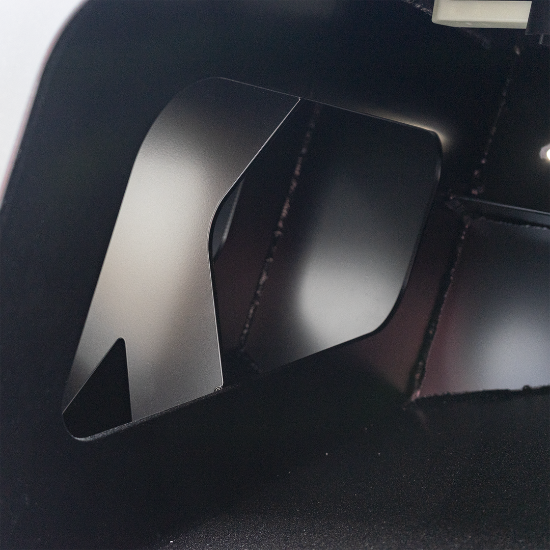 Close-up of a black metal bracket with a rectangular cutout, part of the Black Ops High Flotation Twin Outboard Engine Bracket. The surface is smooth and matte, with visible stitching nearby