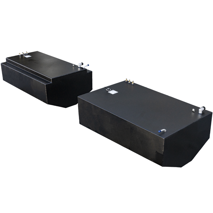 Two black fuel tanks are positioned side-by-side. The tank in the foreground is rectangular with a rounded end, while the one in the background has a raised section on its top. Both tanks feature various pipes and fitting on their top surfaces, and appear to have a textured finish