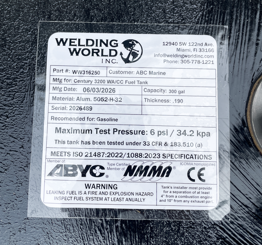 Close-up top-deck hardware layout view of a black Century 3200 WA/CC replacement marine fuel tank. The image focuses on a clear manufacturer specification data placard listing part number WW316250, customer name ABC Marine, and a manufacturing date of 06/03/2026. Fabricated from heavy-gauge marine-grade 5052-H32 aluminum with a thickness of .190, the 300-gallon capacity center-hull tank body is fully encapsulated in a textured, anti-corrosive black TarGard epoxy coating. Every unit is precision-engineered b
