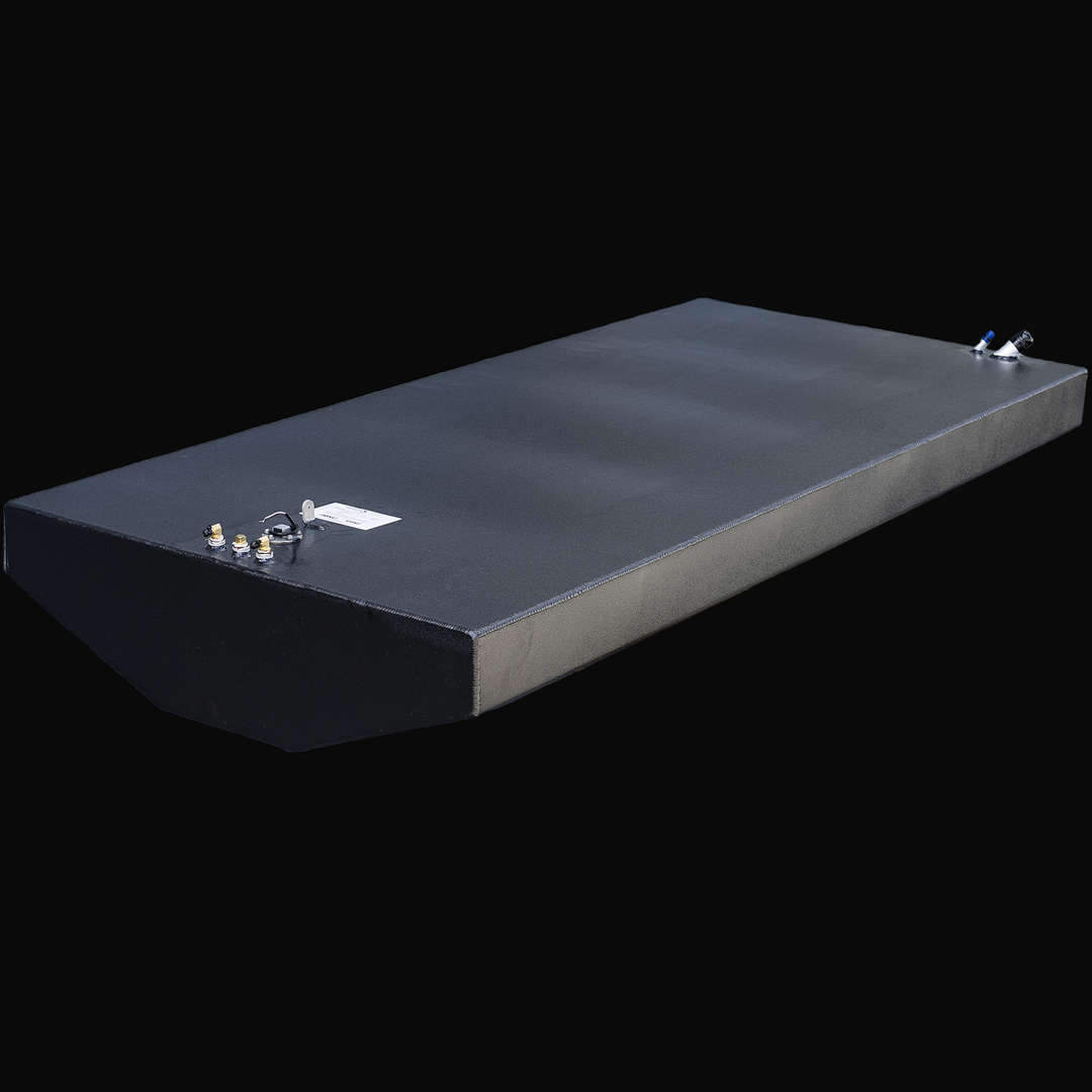 Black rectangular metal fuel tank with a textured finish and a beveled front edge, positioned at an angle showing the top and one side. On the top left corner, there are four brass and metal fittings, along with a white label. On the top right corner, there are two angled black and blue fittings. The tank is identified as a Chris-Craft Scorpion 311, 1989 model, with a nominal capacity of 189 gallons and is an Built to OEM Specs tank