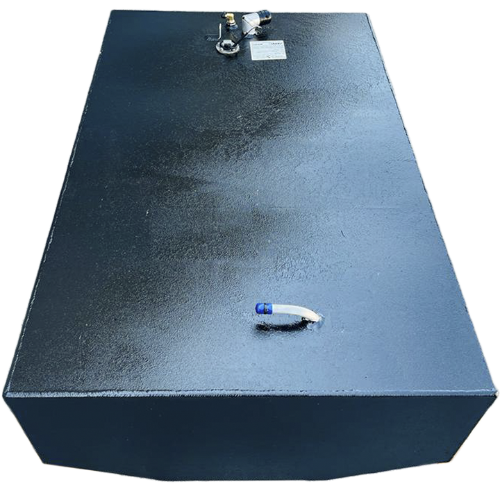 A dark, rectangular fuel tank with a textured surface is positioned against a black and grey checkered background. Various fittings are visible on its top surface, including a white, curved pipe with a blue tip on one end, and a cluster of nozzles and a white label on the other