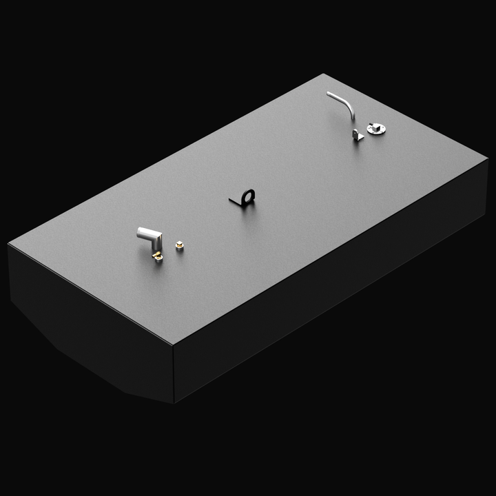 3D rendered image of a rectangular black Built to OEM Specs fuel tank with a textured matte gray top surface. The tank has a slanted front edge. The top includes fittings in silver and brass colors, as well as a black mounting bracket near the center. The image is shown at an angle with a solid black background.