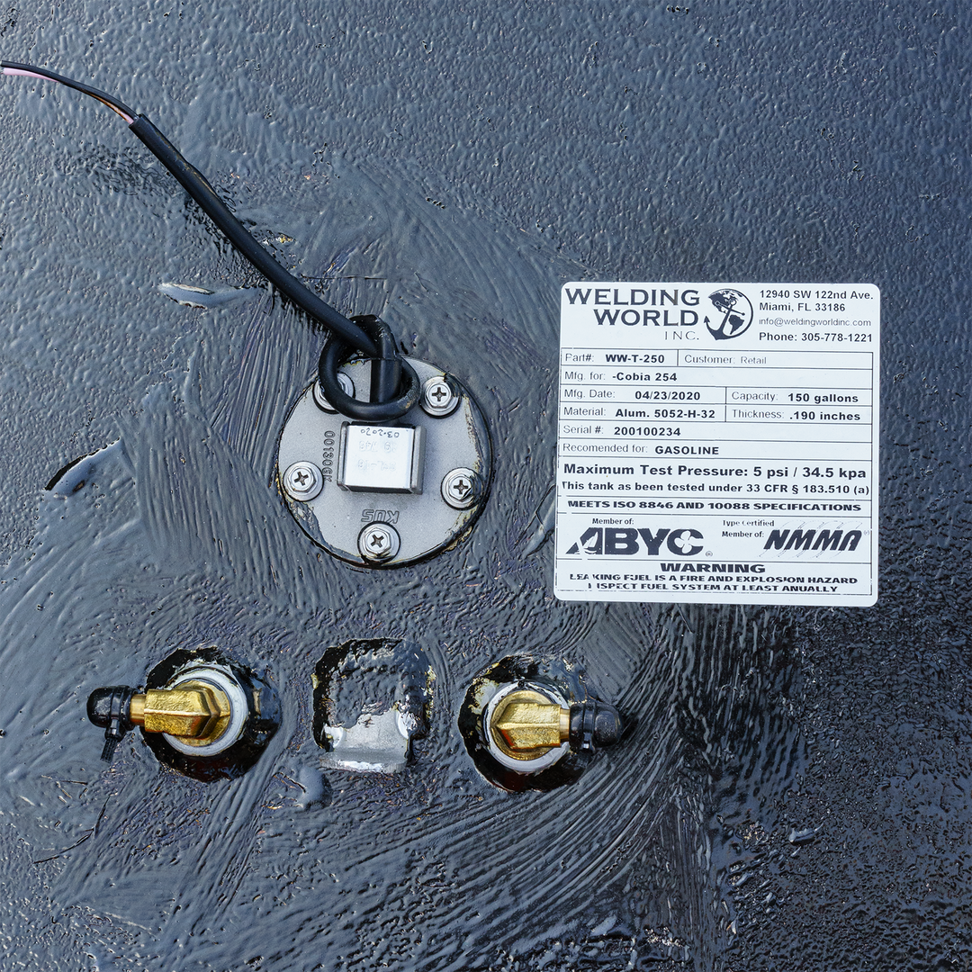 Close-up of a 2006 Cobia 254 OEM replacement fuel tank featuring a fuel gauge and two brass fittings. The tank has a label from Welding World indicating a capacity of 150 gallons, a test pressure of 5 psi, and specifications for gasoline use