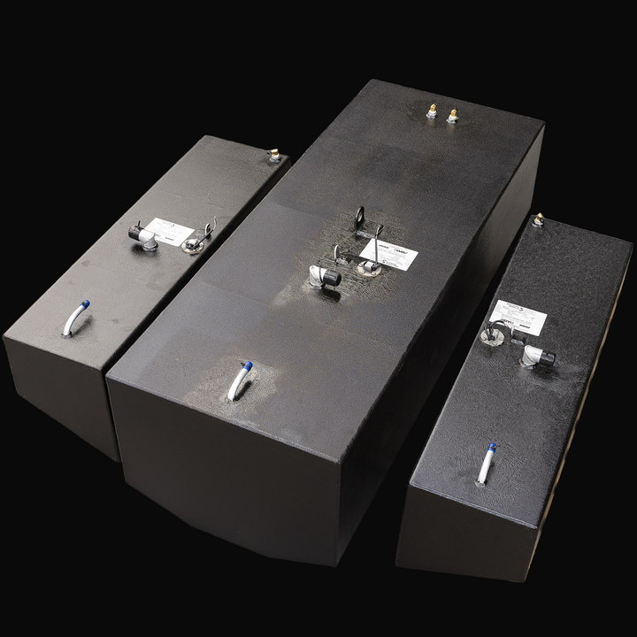 Three black metal fuel tanks arranged on a transparent background. The central tank is the largest with beveled front edges, flanked by two smaller rectangular tanks on each side. Each tank has metal fittings, capped openings, wiring, white plastic tubes on top, and white labels attached