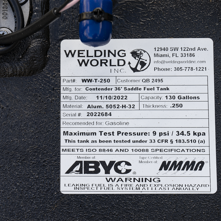 Close-up of a Welding World Inc. label on a black aluminum fuel tank. The label lists part number WW-T-250 for a Contender 36' saddle fuel tank, manufactured on 11/10/2022. Capacity is 130 gallons, made of Aluminum 5052-H-32 with 0.250-inch thickness. Serial number 2022684. Recommended for gasoline. Certified by ABYC and NMMA, meeting ISO 8846 and 10088 specifications. Warning about fire and explosion hazard from leaking fuel. Contact info includes Miami, FL address and phone number 305-778-1221