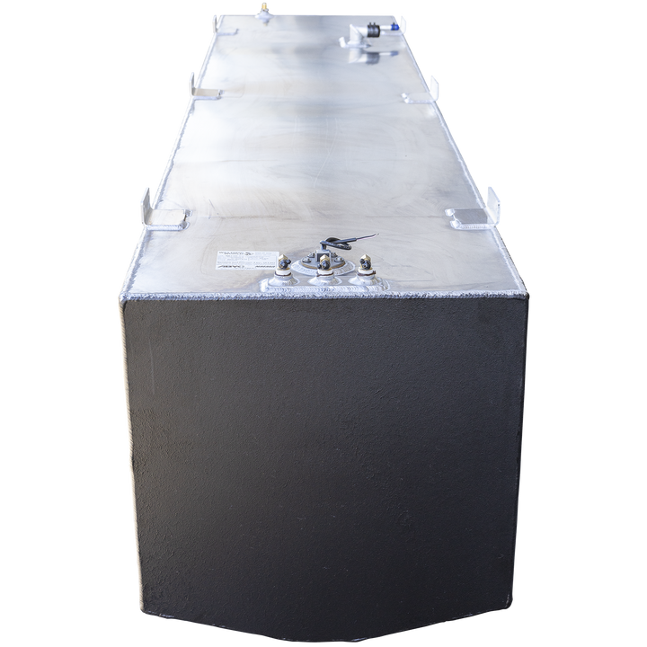 This image shows a large aluminum fuel tank viewed from the front side with the top surface facing upward. The tank has a smooth metallic surface with visible weld seams along the edges and multiple mounting brackets evenly spaced on the top edges. On the front top surface, there are four fittings: three brass connectors and one wire protruding from a central mount. The front face of the tank is painted black with a slightly textured finish. The tank is designed for industrial or marine use 