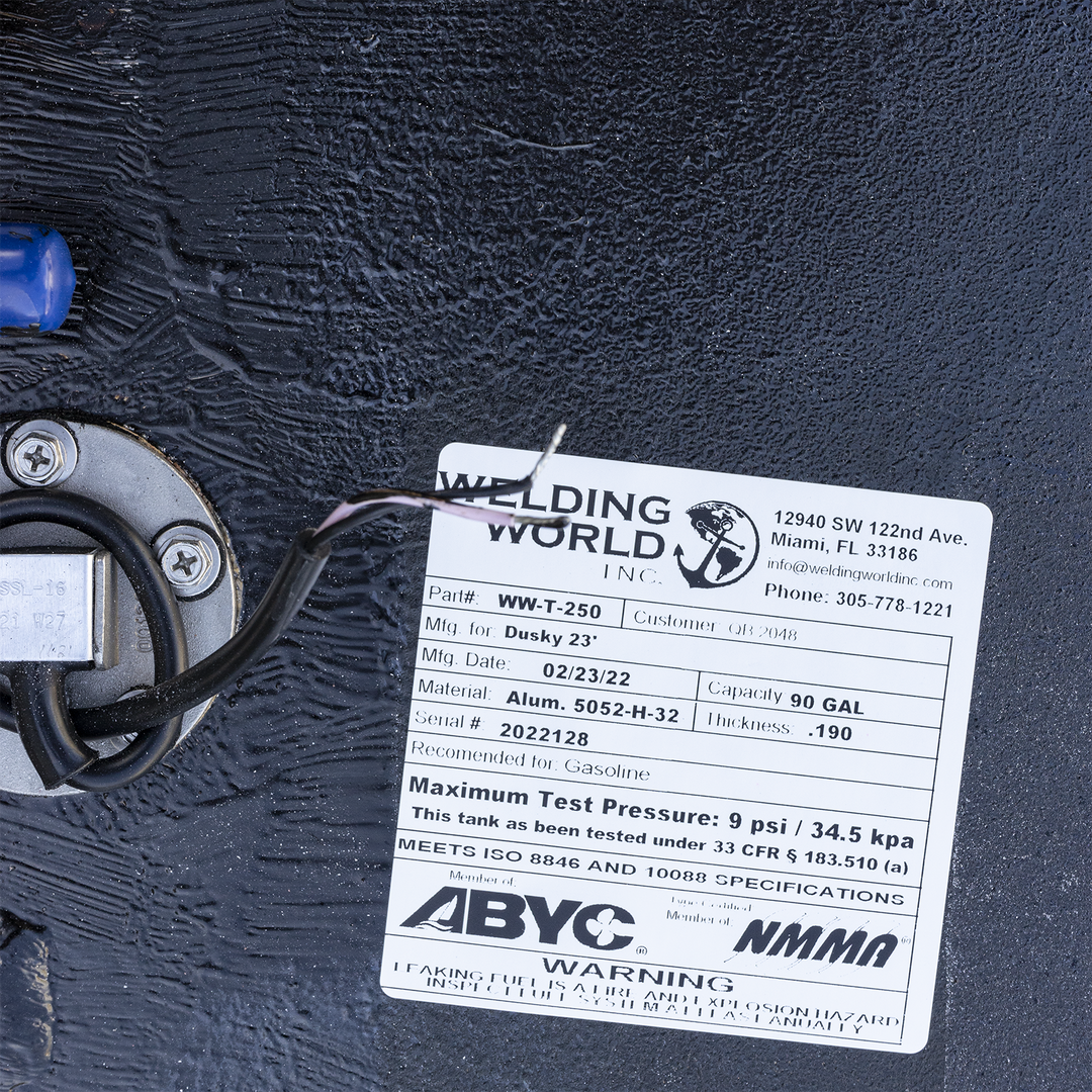 Affixed manufacturer label for 69-gallon aluminum belly fuel tank fabricated by Welding World Inc. for Dusky 23. Label confirms model WW-T-250, serial number 2022128, and February 2022 production date. Constructed from .190" thick 5052-H32 marine-grade aluminum, rated for gasoline use. Tank tested to a maximum pressure of 9 psi (34.5 kPa) in compliance with 33 CFR § 183.510(a), and certified to ISO 8846/10088 standards. Label visibility ensures traceability, inspection readiness, and conformance with ABYC