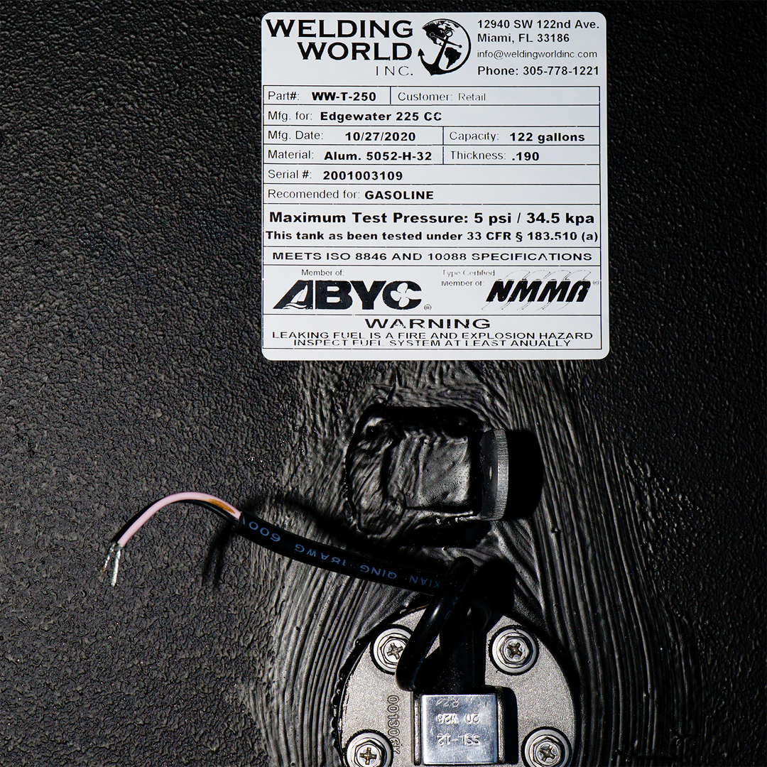 Close-up of the OEM replacement belly fuel tank for Edgewater 225 CC, featuring a capacity of 122 gallons. The tank is labeled with specifications including the model number (WT-250), date of manufacture (10/27/2020), material (aluminum), and maximum test pressure (5 psi / 34.5 kPa). A warning label indicates that the tank is designed for gasoline