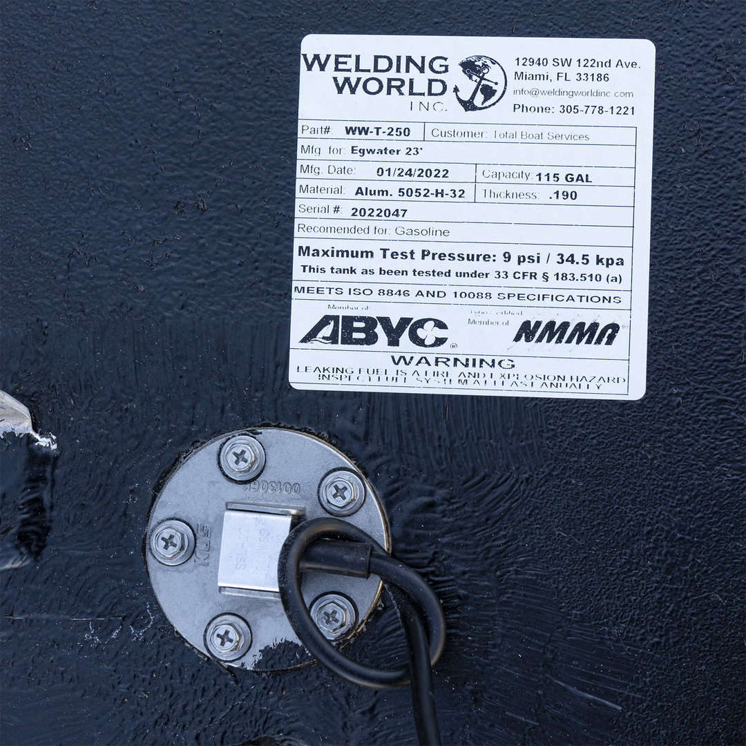 Certification label for the 117-gallon aluminum belly fuel tank installed in the 2005 Edgewater 23 center console. Issued by Welding World Inc. (Part #WW-T-250, Serial #2022047), the label confirms .190″ 5052-H32 marine-grade aluminum construction and specifies compatibility with gasoline. It documents a manufacturing date of 01/24/2022 and lists a 9 psi max test pressure under 33 CFR § 183.510(a). The tank meets ISO 8846 and 10088 standards and includes ABYC and NMMA compliance logos