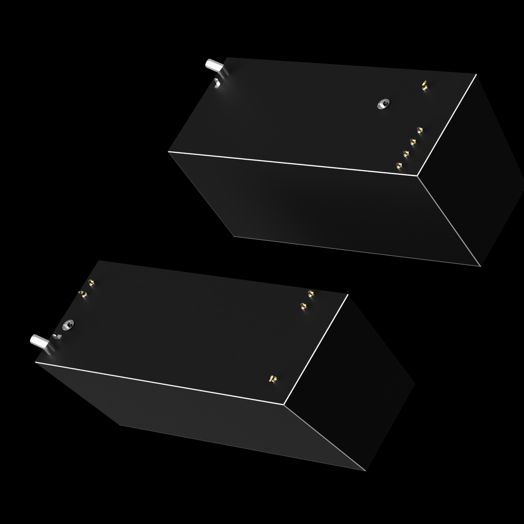 Two dark gray, rectangular fuel tanks are angled against a black background. Both tanks have thin white outlines along their edges and feature various small brass-colored and silver-colored fittings on their top surfaces. One tank is positioned in the upper right, and the other in the lower left