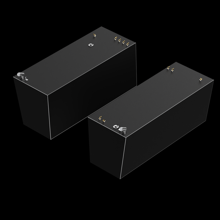Two dark gray, rectangular diesel saddle tanks, each with a 190-gallon capacity, are shown against a black background. Both tanks feature multiple small brass-colored and silver-colored fittings on their top surfaces, and a thin white outline runs along the top edges of both tanks. The tanks are positioned at a slight angle, with one further back and to the left, and the other closer and to the right