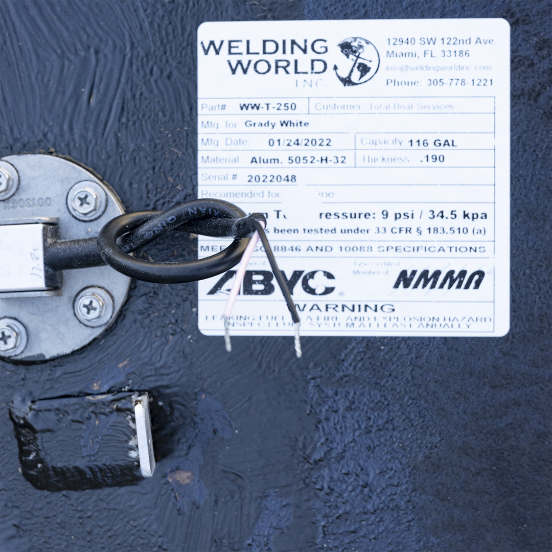 Certification label for the 116-gallon aluminum forward fuel tank installed in the 2001 Grady-White 265 Express OEM replacement kit. Manufactured by Welding World Inc. (Part #WW-T-250, Serial #2022048) using .190″ 5052-H32 marine-grade aluminum. The tank meets ABYC H-24, H-33, and NMMA standards, and is tested under 33 CFR § 183.510(a) with a recommended pressure of 9 psi. Manufacturing date: 01/24/2022. Safety warning highlights the risks of fuel leaks and the need for annual system inspections