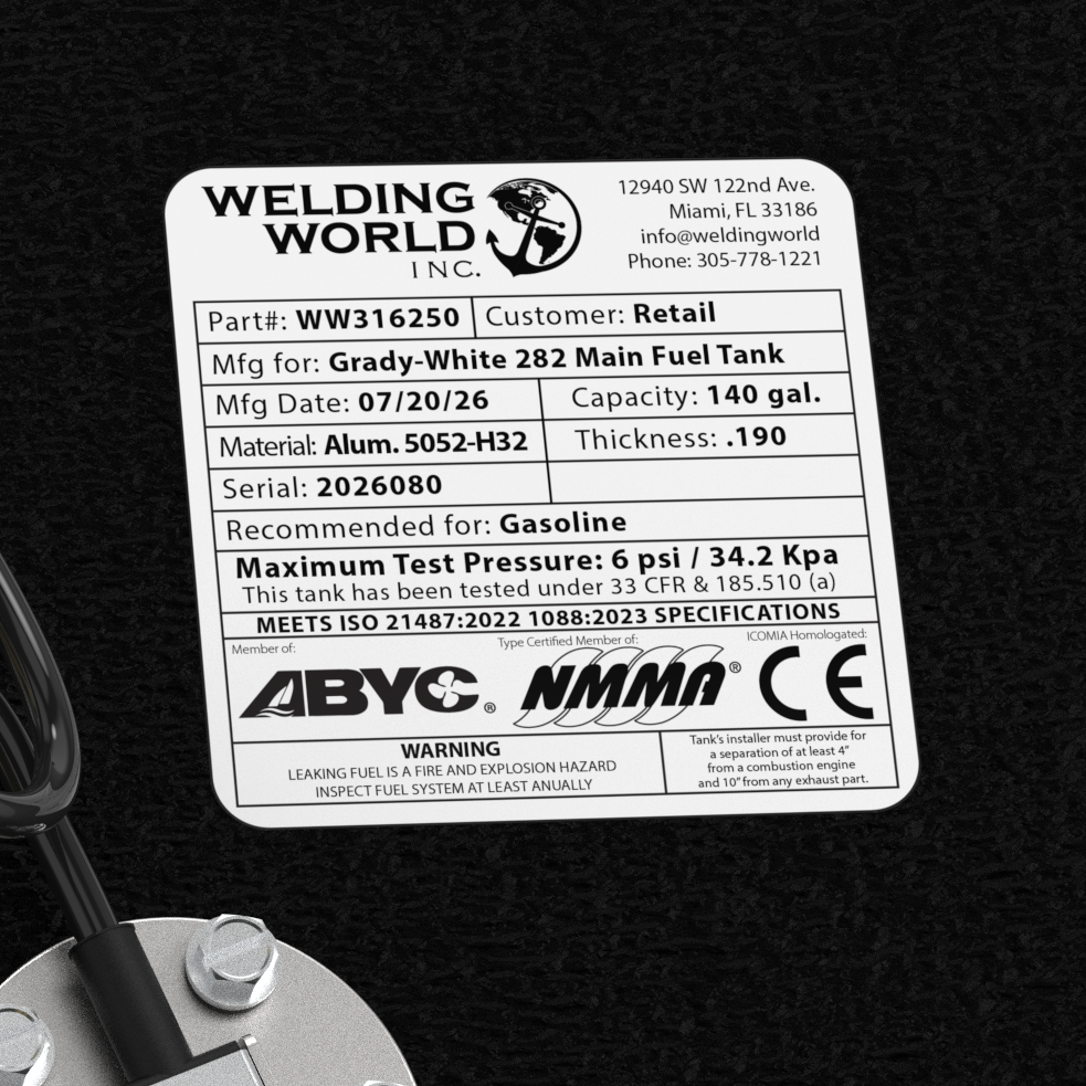 A macro top-down studio view of the top deck hardware cluster and certification label on a physical, finished black encapsulated Grady-White 282 Sailfish Main OEM replacement fuel tank (140 gal) from file image_f14b58.jpg. Positioned against the textured black TarGard epoxy coating, the hardware includes a central circular silver KUS electronic fuel level sending unit fastened with five bolts and fitted with a coiled black wiring lead. Surrounding the sender are dual pre-installed high-flow brass 90-degree 