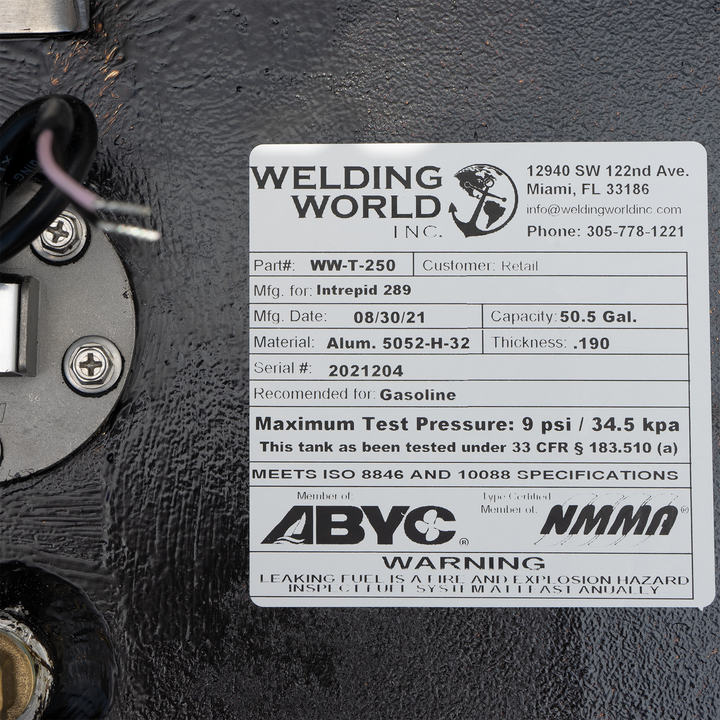 A white label on a black fuel tank, detailing specifications for a 50.5-gallon auxiliary fuel tank for an Intrepid 289, manufactured by Welding World Inc. on 08/30/21. The label includes the part number WW-T-250, material as Alum. 5052-H-32 with a thickness of .190, serial number 2021204, and states it is recommended for gasoline with a maximum test pressure of 9 psi / 34.5 kpa. It also notes that the tank meets ISO 8846 and 10088 specifications and is a member of ABYC and NMMA, with a warning about leaking
