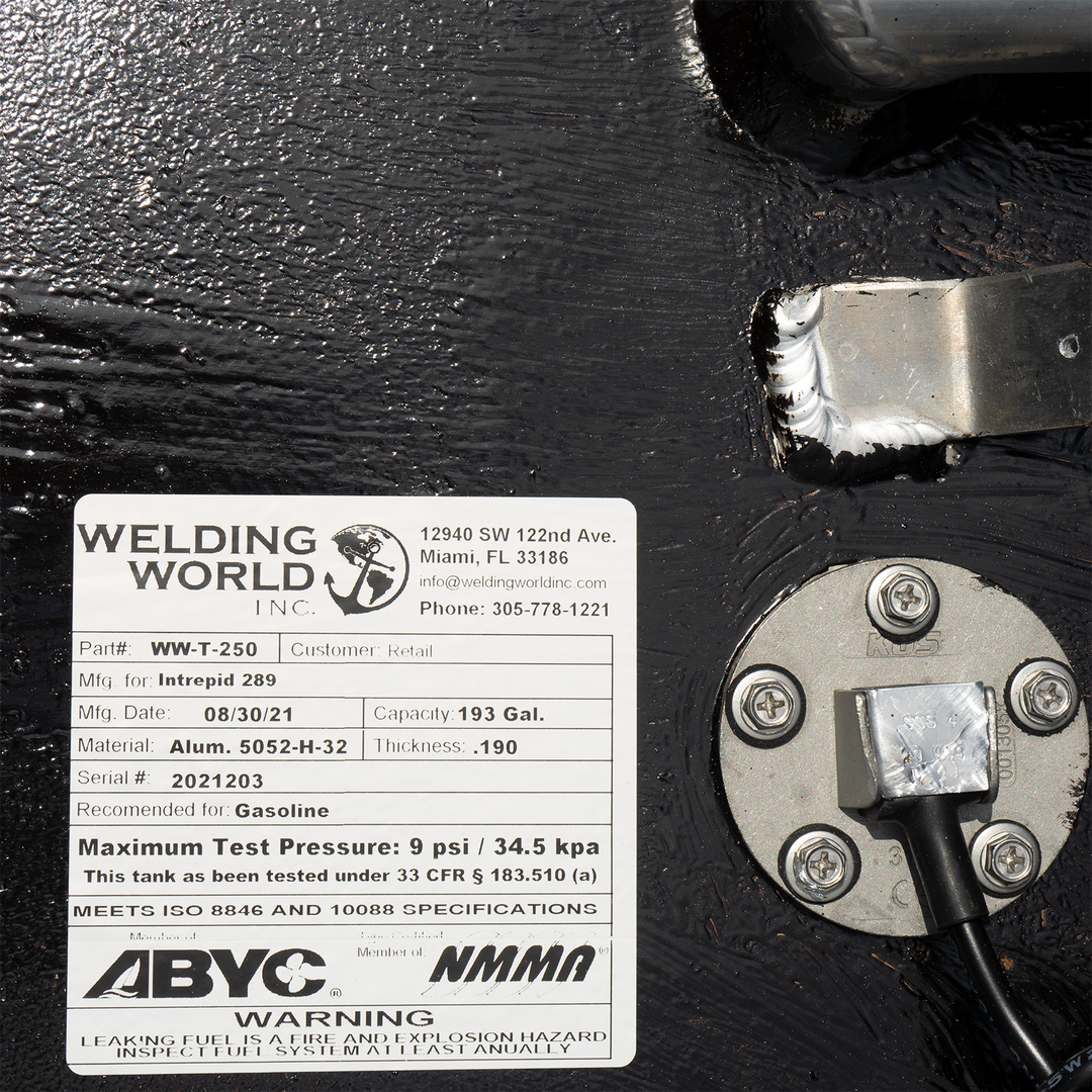 A label on a black fuel tank for an Intrepid 289, indicating it is a 193-gallon main fuel tank manufactured by Welding World Inc. on 08/30/21. The label includes the part number WW-T-250, material as Alum. 5052-H-32 with a thickness of .190, serial number 2021203, and states it is recommended for gasoline with a maximum test pressure of 9 psi / 34.5 kpa. It also notes that the tank meets ISO 8846 and 10088 specifications and is certified by ABYC and NMMA, with a warning about leaking fuel