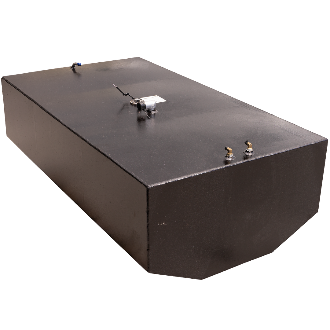 A black, rectangular fuel tank with multiple metal fittings on its top surface, including two brass-colored valves, a silver-colored pump, and a white tube with a blue tip. The tank is positioned against a black and grey checkered background