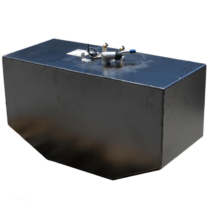 A black, rectangular fuel tank with a slightly textured finish is shown against a black and grey checkered background. Various metallic and plastic fittings are visible on its top surface, including brass-colored valves, a silver-colored component with a blue-tipped tube, and a small white label