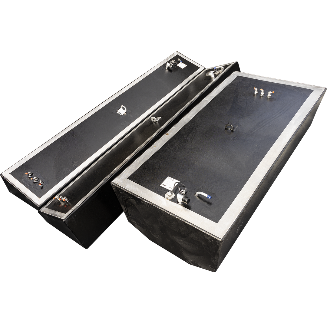 Three boat fuel tanks, one large and two smaller, are angled on a black and grey checkerboard background. The tanks are black with silver trim and various metallic fittings on their top surfaces. The large tank is in the foreground on the right, while the two smaller tanks are positioned behind and to the left of it