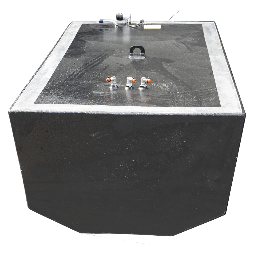 A large, black fuel tank, likely for a boat, is shown against a checkerboard background. It has a broad, rectangular top surface with a silver-colored trim around the edge. Various metal fittings and connectors are visible on the top, including three small, orange-tipped valves in the foreground and a larger, U-shaped handle near the center. The tank's body is also black and appears to have a slightly textured finish