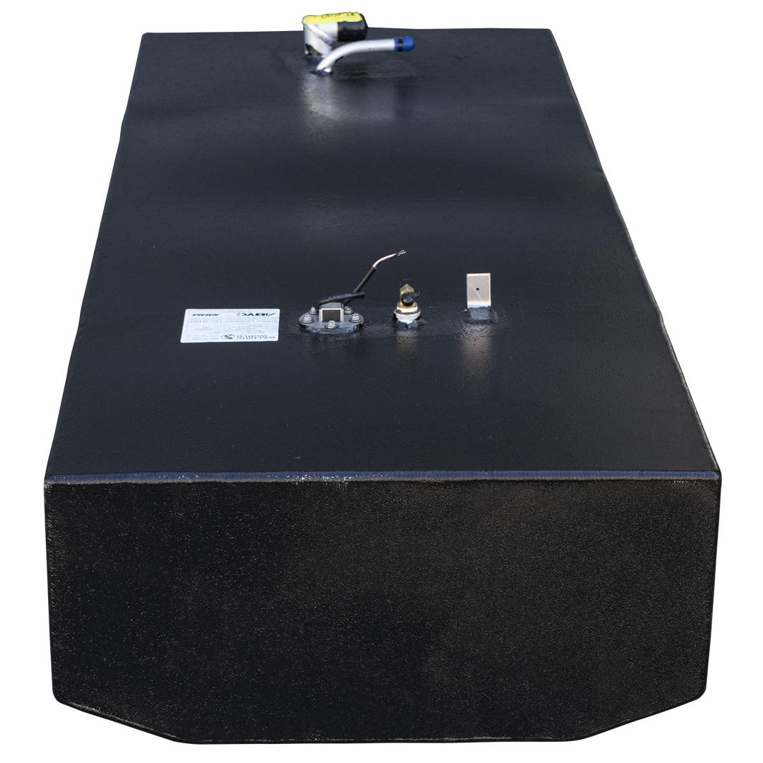A frontal view of a long, rectangular boat fuel tank with a textured black finish, shown against a checkered background. The front bottom edge is cut with two angles to form a shallow V-shape. On the top surface in the foreground, there is a fuel sending unit on a round base, a brass fitting, a small vertical tab, and a white label. At the far end of the tank, a second fuel fitting assembly with a yellow top is visible