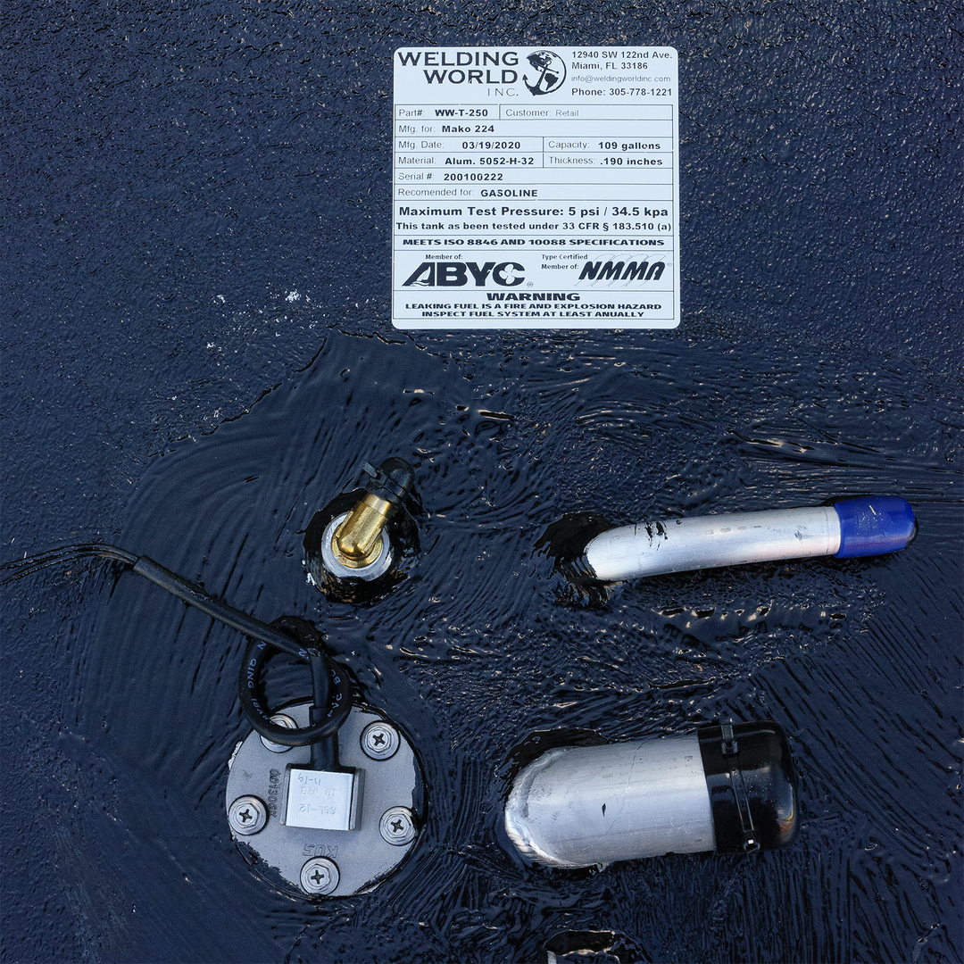 Close-up of a fuel tank for a 1984 Mako 224, featuring a label from Welding World with specifications, a fuel gauge, and fuel lines submerged in liquid