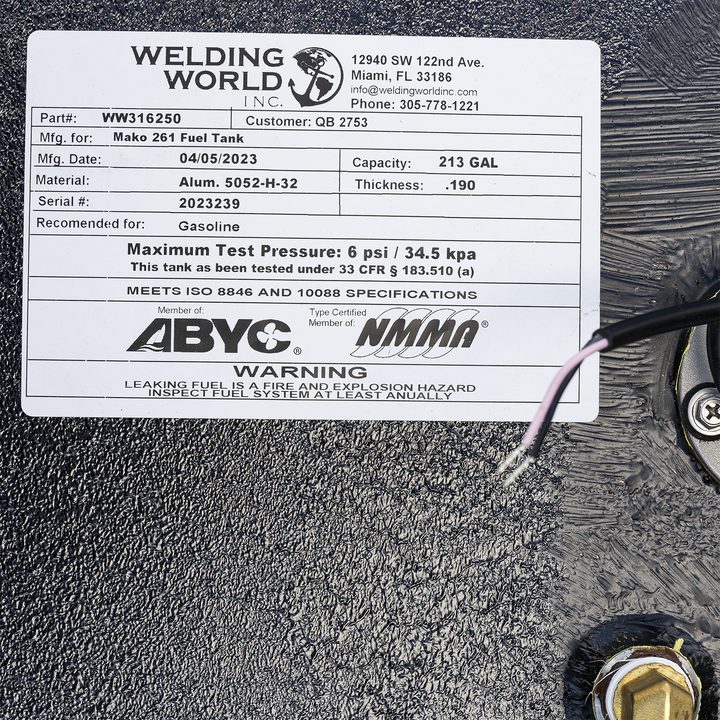 Black rectangular Mako 261 fuel tank with welded brackets along the top edges, multiple fittings and a fuel sending unit on the top surface, textured black finish, photographed at an angle showing the top and two sides