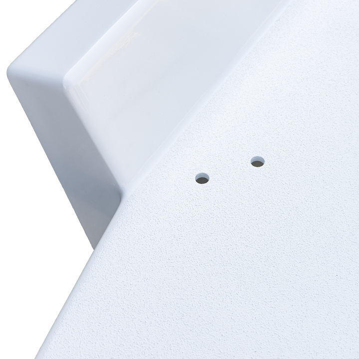 A close-up view of a white boat surface with two small circular holes and a curved edge, part of a Mako 261 1990 twin engine high flotation bracket, with a textured finish and smooth, rounded corner.

