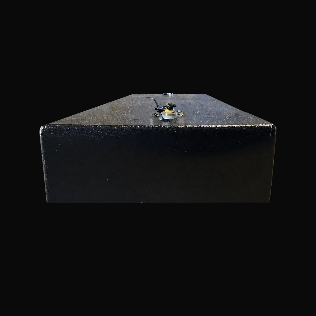 A studio low-angle rear end perspective view highlighting the 8-inch low profile and flat hull bottom of a physical, finished black encapsulated Paramount 21 2025 OEM replacement marine fuel tank (84 gal) from file image_c21384.jpg, isolated against a black background. Precision-fabricated from heavy-gauge .190" marine-grade 5052-H32 aluminum, the elongated rectangular body is fully encapsulated in a protective, textured black TarGard epoxy coating to resist severe saltwater pitting and bilge moisture decay