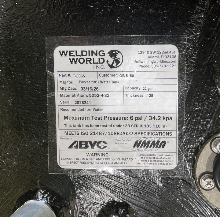 Close-up of the Welding World Inc. manufacturing label for a Parker 2301 (22 gal) water tank replacement. The label confirms the use of marine-grade 5052-H32 aluminum, a 6 psi pressure test certification, and compliance with ISO 21487/1088:2022 standards. This high-build Coal Tar Epoxy coated tank is verified for a guaranteed OEM fit, meeting all ABYC and NMMA specifications for marine freshwater systems.