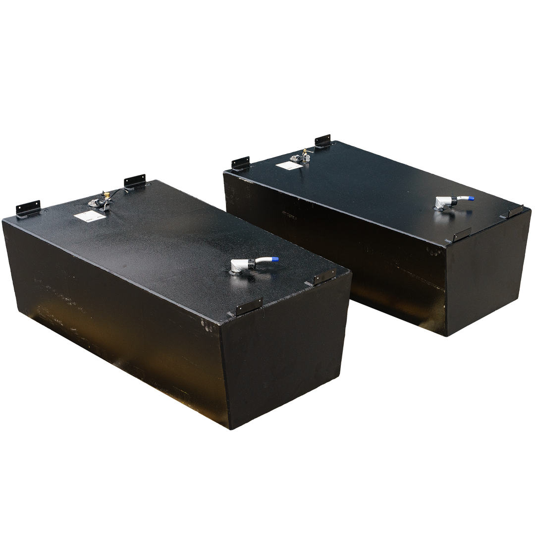 A pair of black, textured, rectangular fuel tanks, shown from an elevated perspective. Each tank features metal brackets on the corners of its top surface and several cylindrical fittings, one with a blue cap, protruding from the top. The background is a black and grey checkerboard pattern