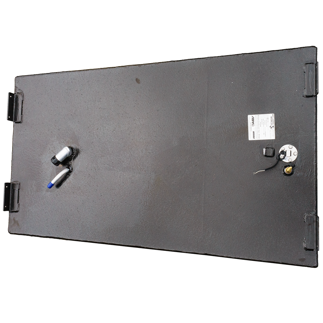 An overhead view of a black, rectangular marine fuel tank with a textured finish. Four black mounting brackets are visible at the corners of the top surface. Towards the right, a white product label is affixed next to a circular fuel sender unit with attached wires and a brass fitting. On the left side, two silver-colored hose fittings, one with a blue cap, protrude from the tank's surface. The tank is displayed against a black and grey checkered background