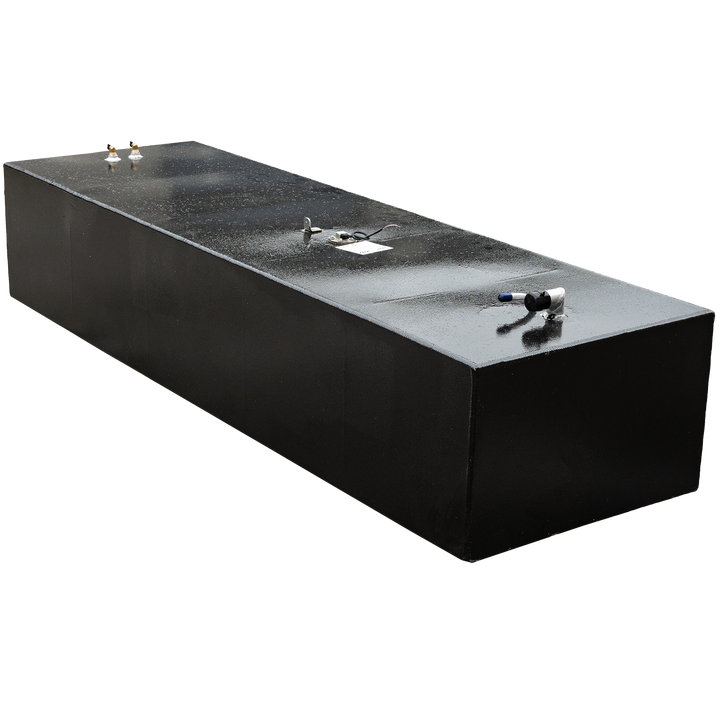 A dark, elongated, rectangular fuel tank with a slightly textured top surface, featuring various metallic fittings and pipes, against a black and grey checkered background