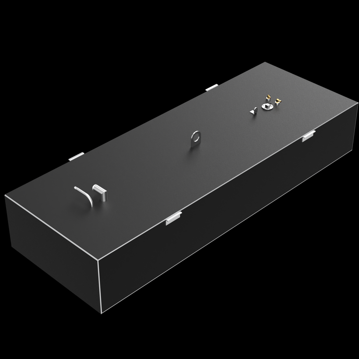 A dark grey, elongated rectangular fuel tank with golden and silver-colored fittings on its top surface, including pipes, valves, and a large D-ring. Small white rectangular brackets are visible along the edges of the top surface. The tank is positioned at an angle against a black background with subtle white dots