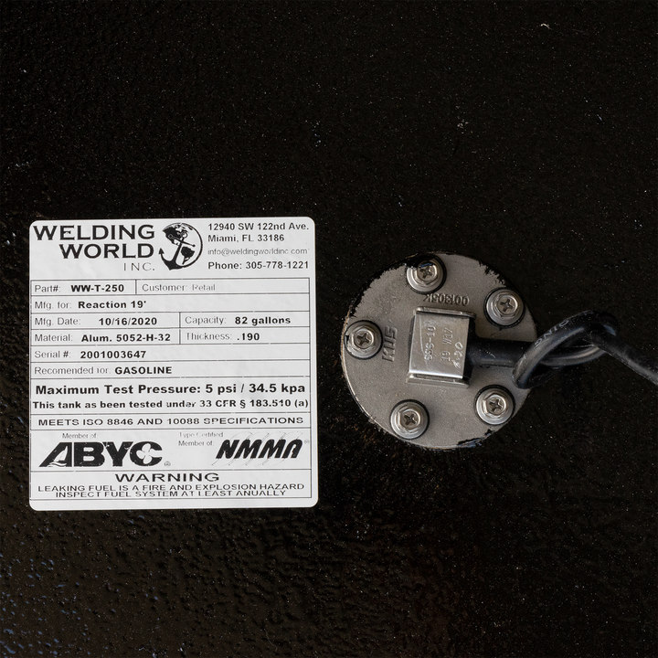 Close-up of a Welding World INC fuel tank label and sending unit, detailing specifications like capacity, material, and safety warnings