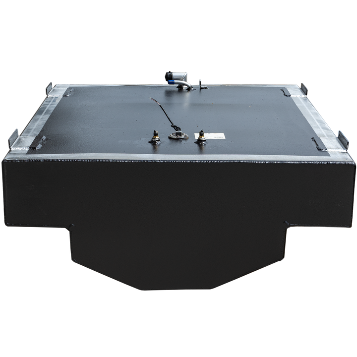 A black, rectangular fuel tank with a textured surface and a metallic frame around its top edge. Various fittings, including a fuel sender and a hose connection, are visible on the top surface. The tank has a stepped cut-out on its bottom left and right side