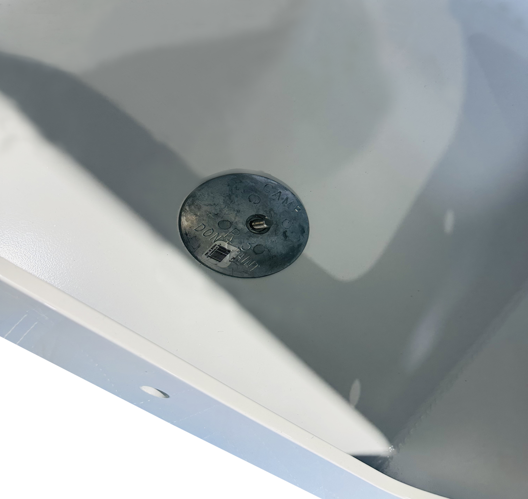 A close-up high-angle shot of a circular zinc anode mounted inside the white flotation chamber. The anode is stamped with "DO NOT PAINT" and is secured with a central bolt.