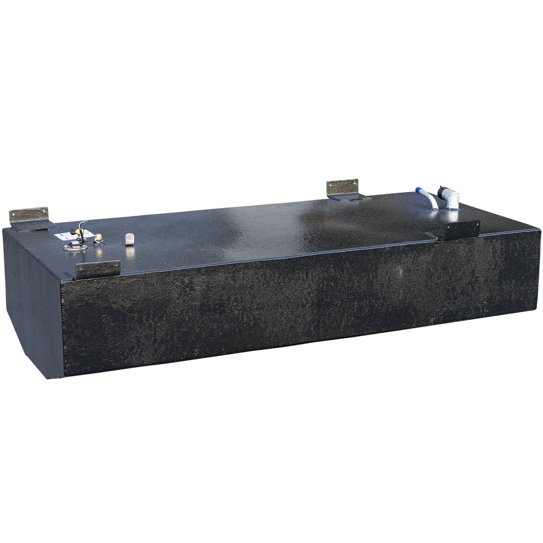 A long, rectangular black fuel tank with a slightly rounded front end, viewed from above and at an angle. The top surface is wet and reflective, showing various metal fittings and connections, including a white and blue pipe assembly on the right and a circular fitting with multiple small pipes on the left. Four dark metal brackets are attached to the top edges of the tank