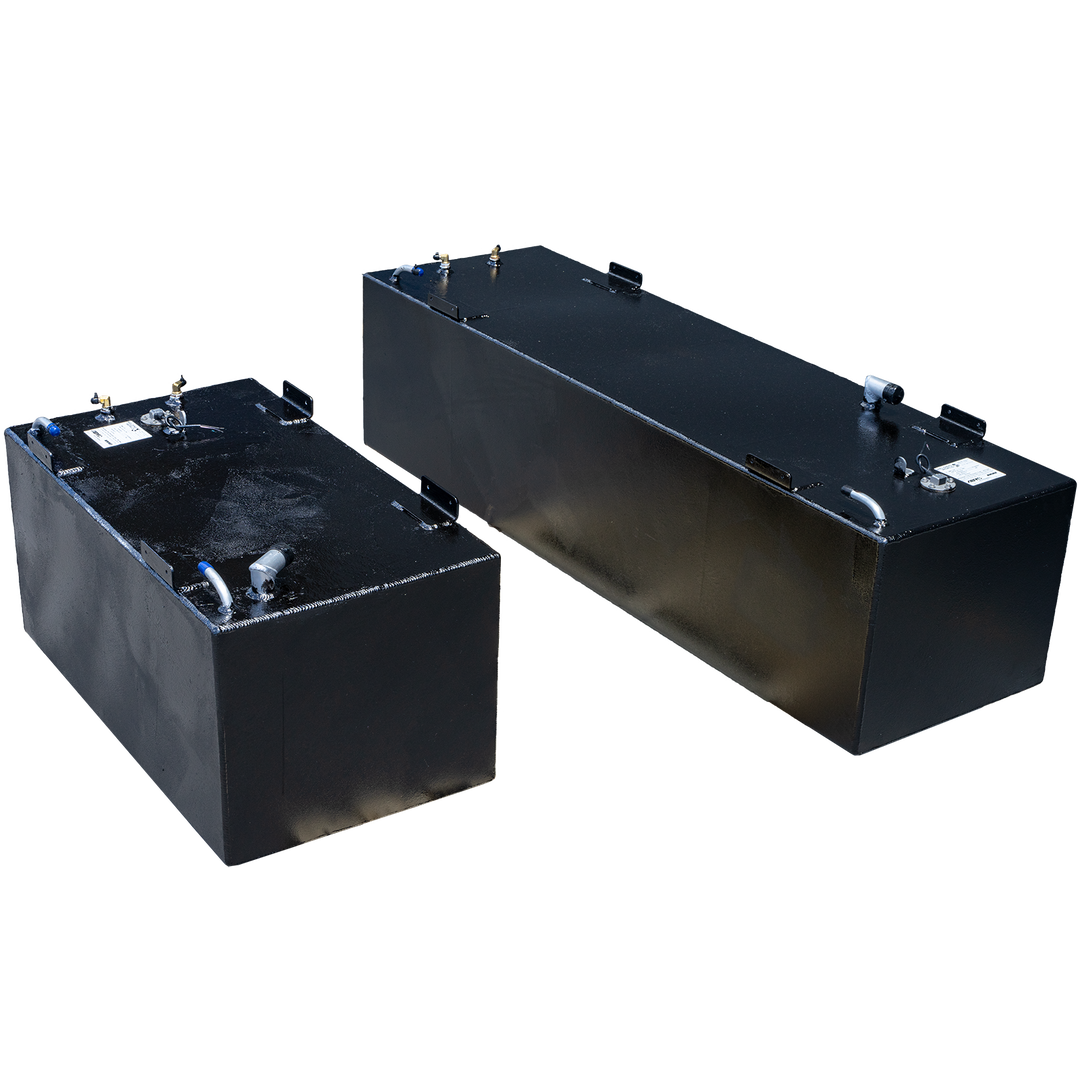 Two rectangular, dark-colored fuel tanks, likely part of a SeaVee 29' 2003 2-Tank Combo 125 & 64 gal. OEM Replacement Fuel Tank Kit, are positioned against a transparent checkerboard background. The tank in the foreground appears smaller, with various metal fittings and connections on its top surface, including brass-colored connectors and silver pipes. The tank in the background is larger and longer, also featuring multiple fittings on its top. Both tanks have a slightly textured finish